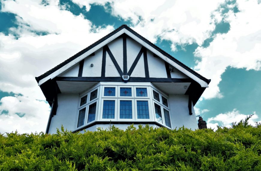 tudor style home rising above green hedges